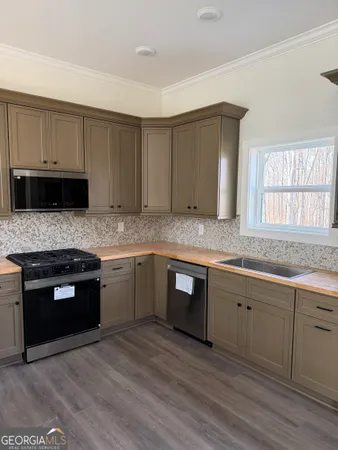 a kitchen with granite countertop cabinets stainless steel appliances and a sink