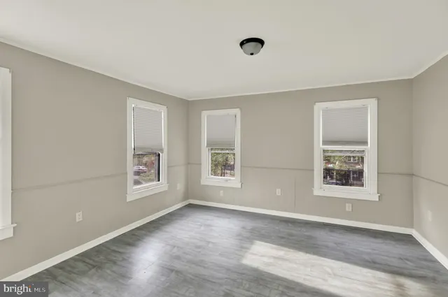 an empty room with windows and closet