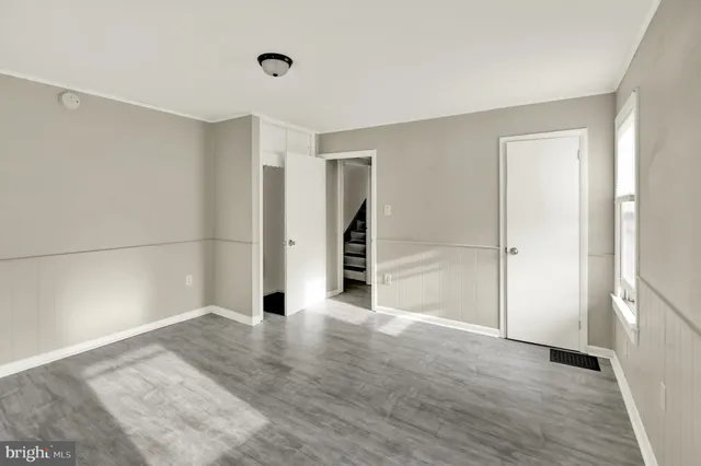 a view of a room with wooden floor and entryway