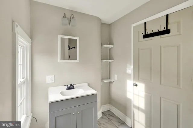 a bathroom with a granite countertop sink and a mirror