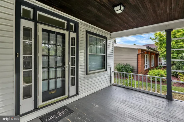 a view of a porch with wooden floor and iron stairs