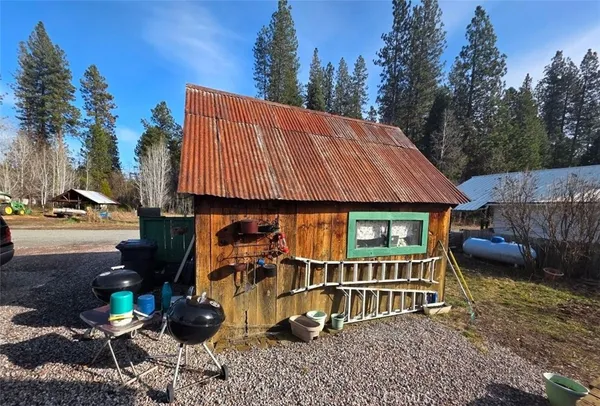 a backyard of a house with barbeque oven and outdoor seating
