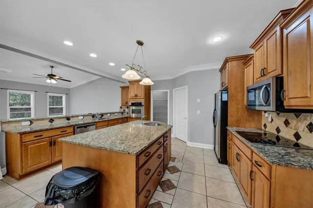 a kitchen with stainless steel appliances granite countertop a refrigerator a stove and a sink