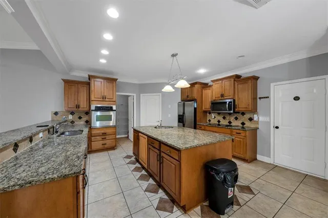 a kitchen with granite countertop stainless steel appliances a stove sink and microwave