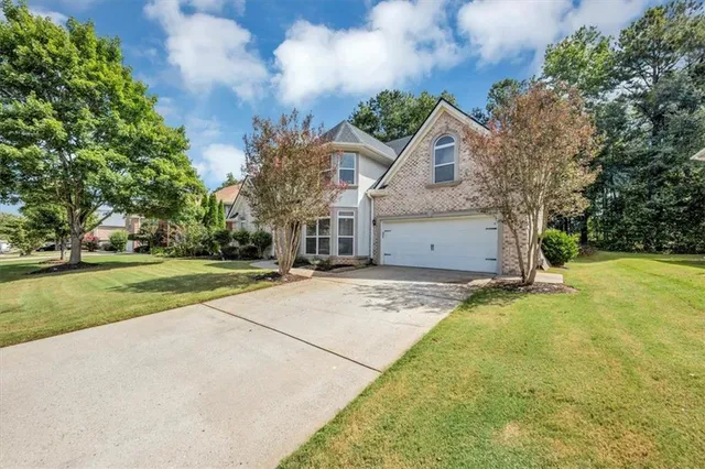 a view of an empty room with wooden floor and a fireplace