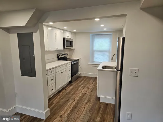 a kitchen with white cabinets and stainless steel appliances