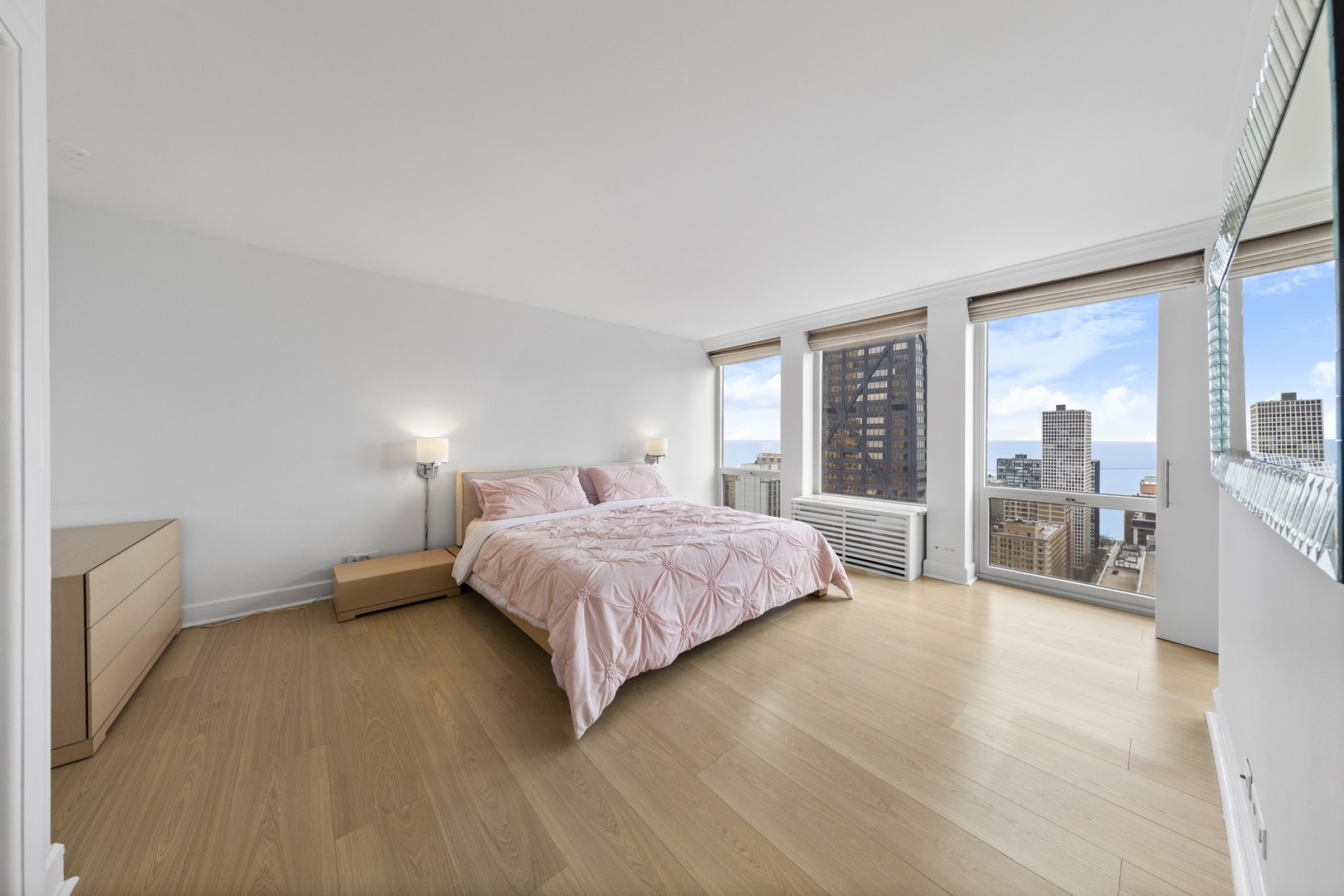 111 East Chestnut Street, Unit 38C Chicago, IL 60611 - Photo 17 of 39 a spacious bedroom with a bed and large windows