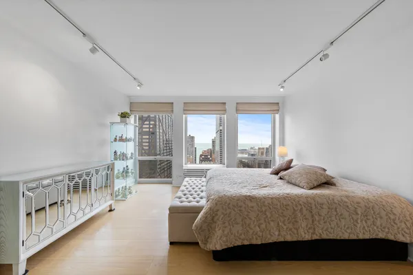 a bedroom with a large bed and a wooden floor