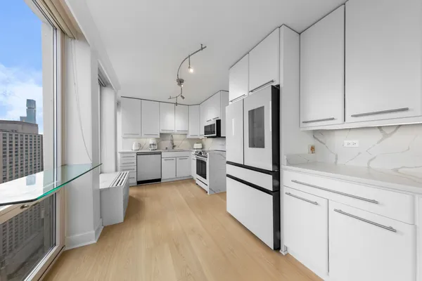 a kitchen with white cabinets and appliances