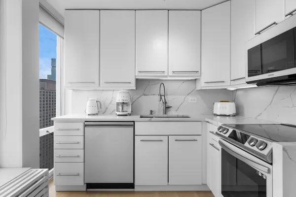 a kitchen with a refrigerator and white cabinets