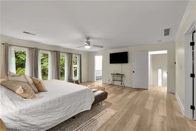 a large bedroom with a bed and large flat screen tv