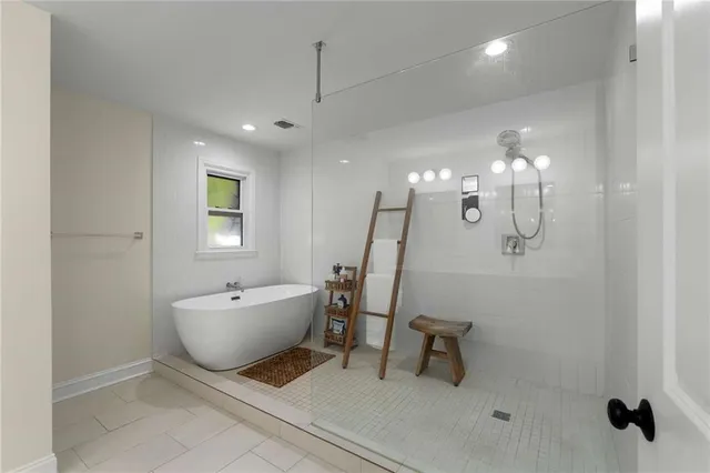 a spacious bathroom with a sink a tub and a mirror