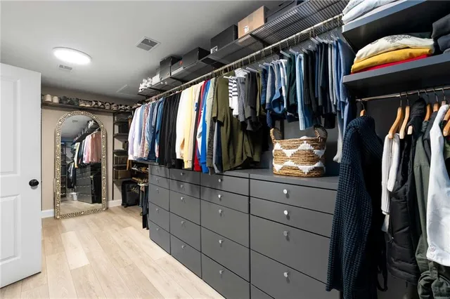 a view of walk in closet with clothes and shoes