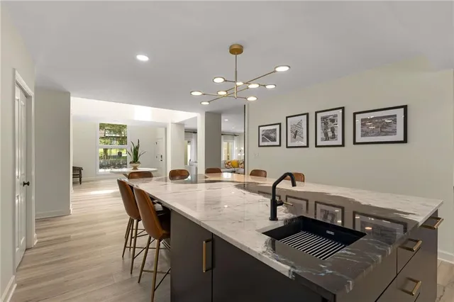 a dining hall with stainless steel appliances granite countertop a dining table and chairs with wooden floor