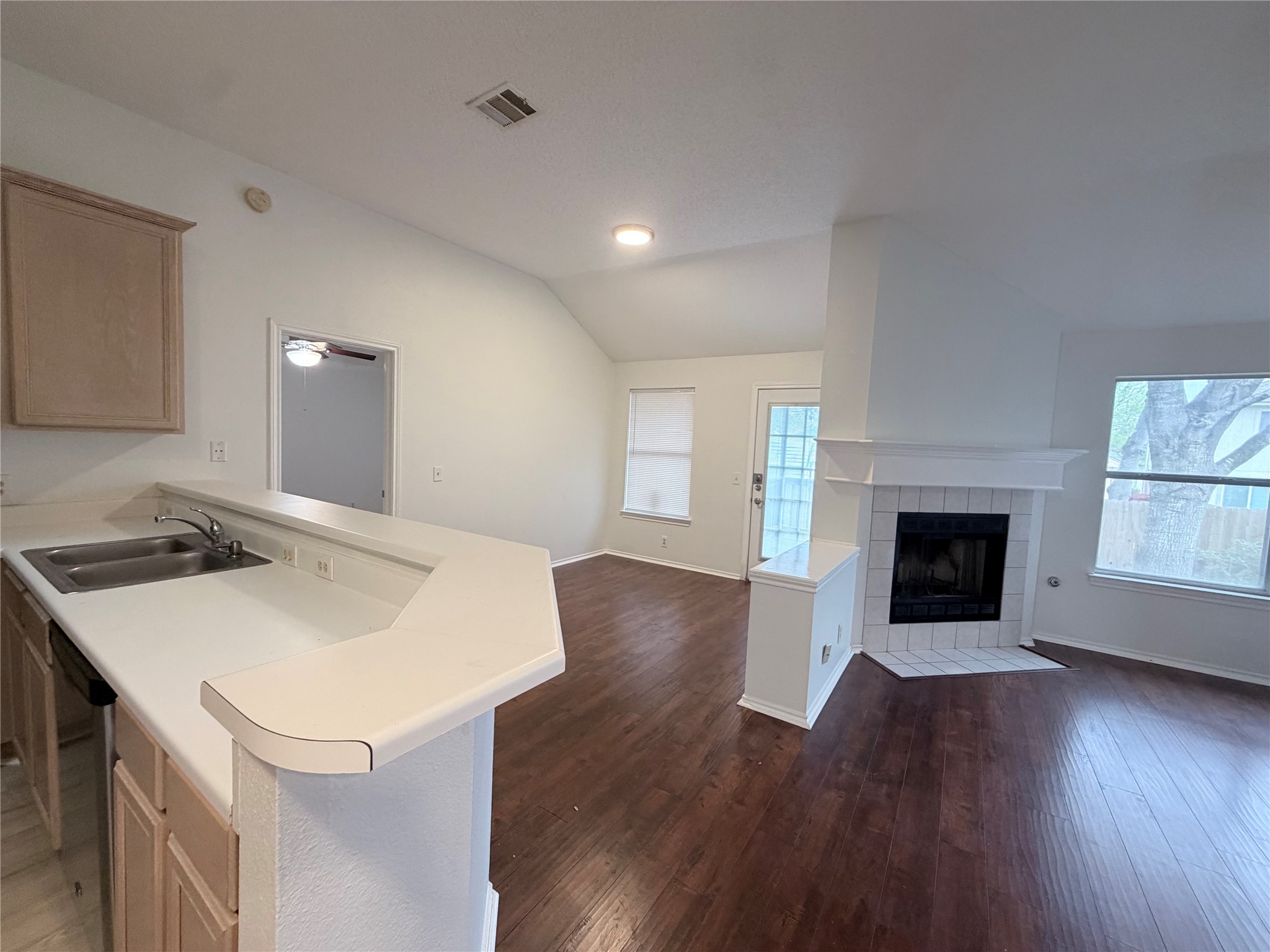 20809 Pacers Gait Lane Pflugerville, TX 78660 - Photo 23 of 23 Kitchen with light countertops, open floor plan, dark wood finished floors, a peninsula, and vaulted ceiling