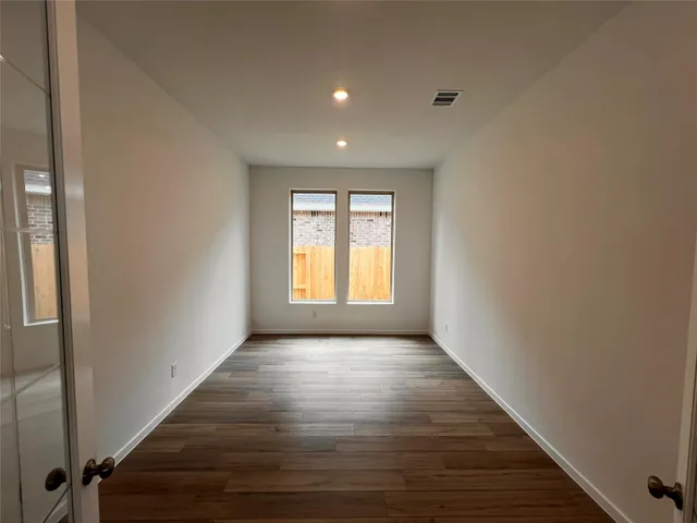 a view of a room with wooden floor and window