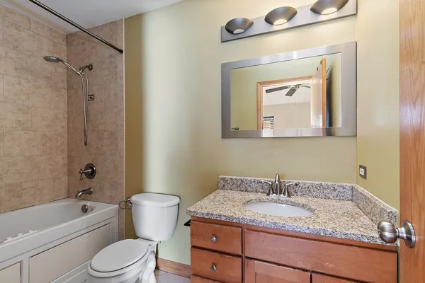 a bathroom with a granite countertop sink toilet and shower