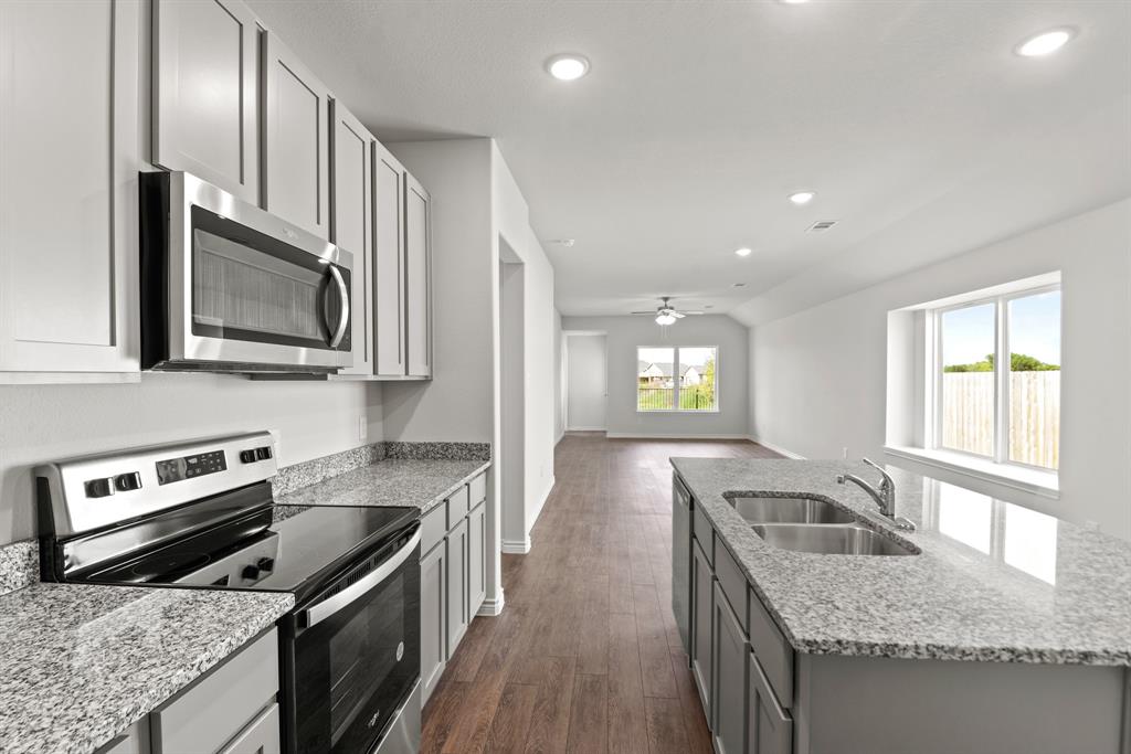 5024 Cervinae Road Crowley, TX 76036 - Photo 3 of 38 a kitchen with stainless steel appliances granite countertop a sink stove microwave and refrigerator
