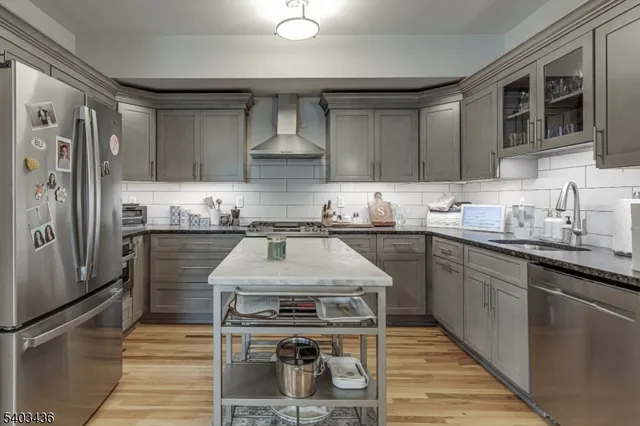 a kitchen with kitchen island granite countertop a sink stove and refrigerator