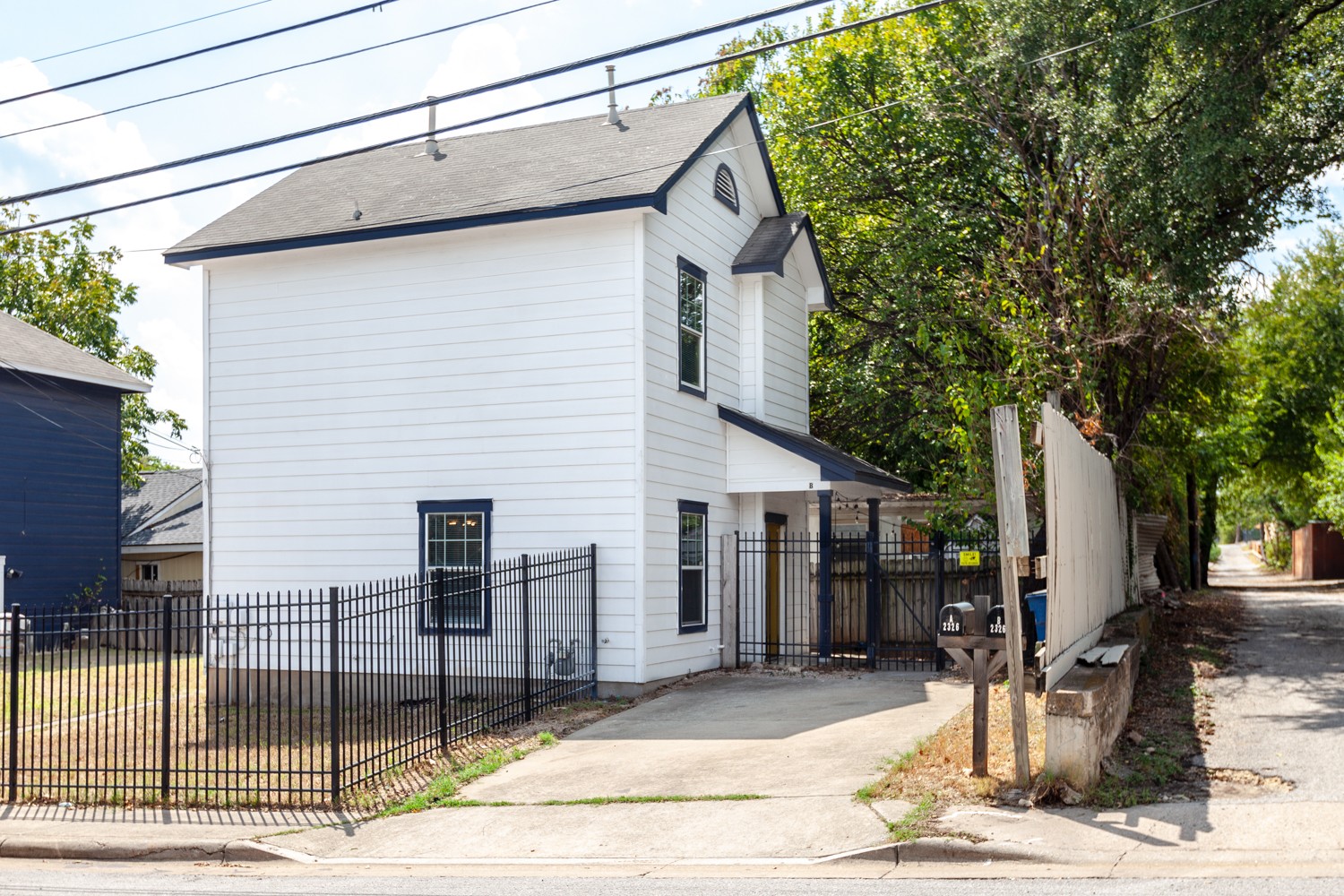 Two-story residence featuring white siding and black trim accents