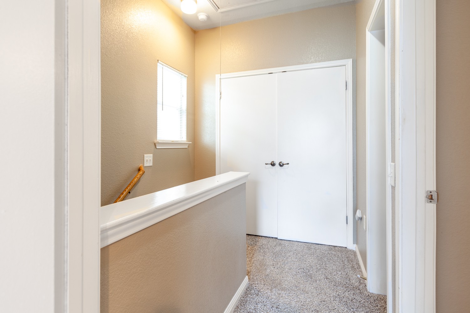 2326 Webberville Road, Unit B Austin, TX 78702 - Photo 13 of 15 Second-story landing featuring neutral wall paint, white trim, and light-colored carpeting