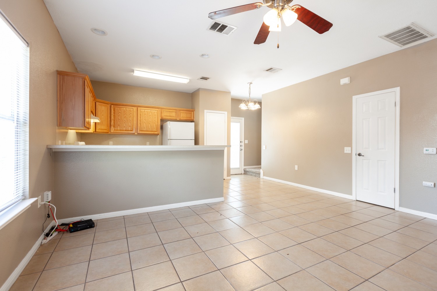 2326 Webberville Road, Unit B Austin, TX 78702 - Photo 7 of 15 Open-concept living space featuring tile flooring, a breakfast bar, wood cabinetry, a ceiling fan, and recessed lighting