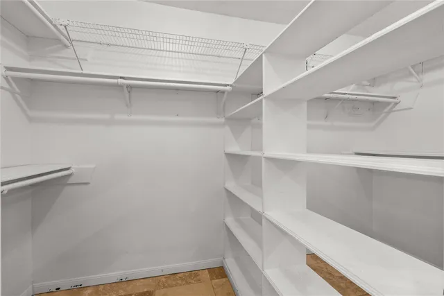 a view of walk in closet with empty racks