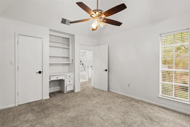 a view of empty room with a ceiling fan and window