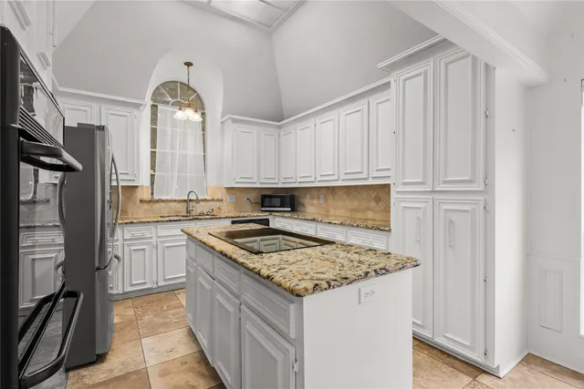a kitchen with stainless steel appliances granite countertop a stove and a refrigerator