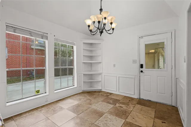 a view of a livingroom with a chandelier fan and windows