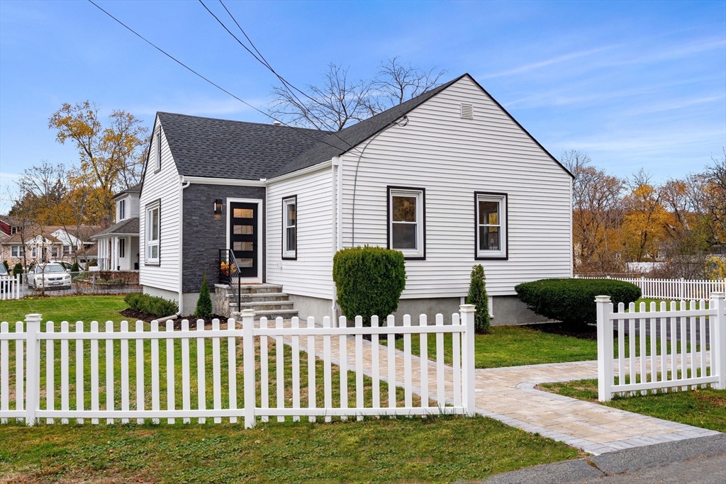 a front view of house along with deck and yard