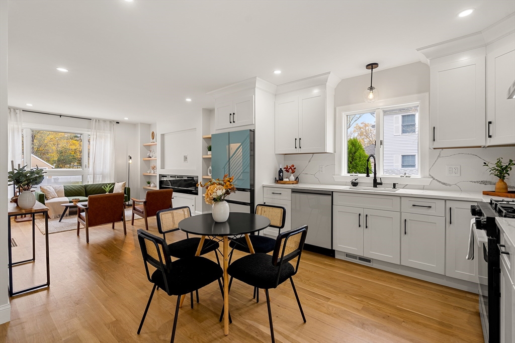 7 Davis Street Saugus, MA 01906 - Photo 12 of 42 a kitchen with stainless steel appliances kitchen island granite countertop a dining table chairs and white cabinets