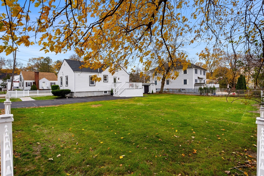 7 Davis Street Saugus, MA 01906 - Photo 4 of 42 a view of a white house in front of a big yard with plants and large trees