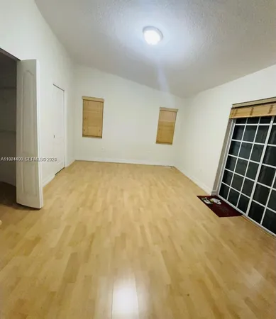 a view of an empty room with wooden floor