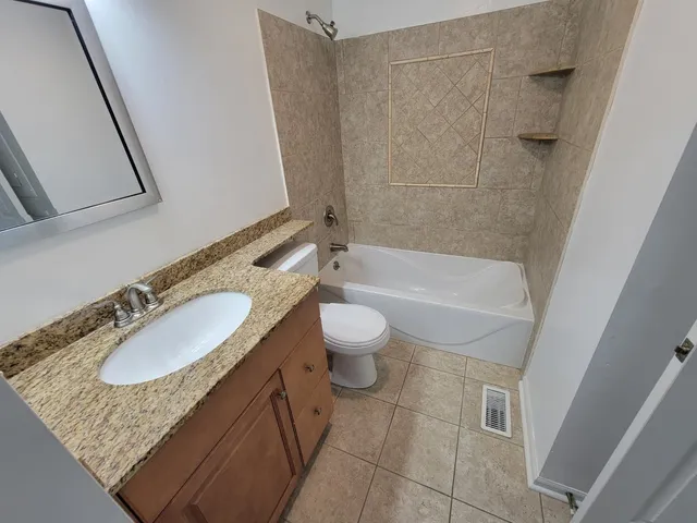 a bathroom with a granite countertop sink toilet and shower