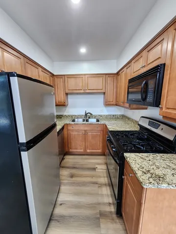 a kitchen with granite countertop a refrigerator stove and microwave