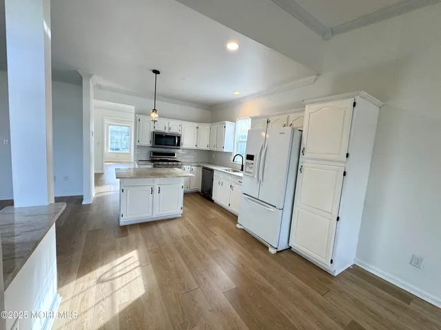 a large kitchen with cabinets and wooden floor