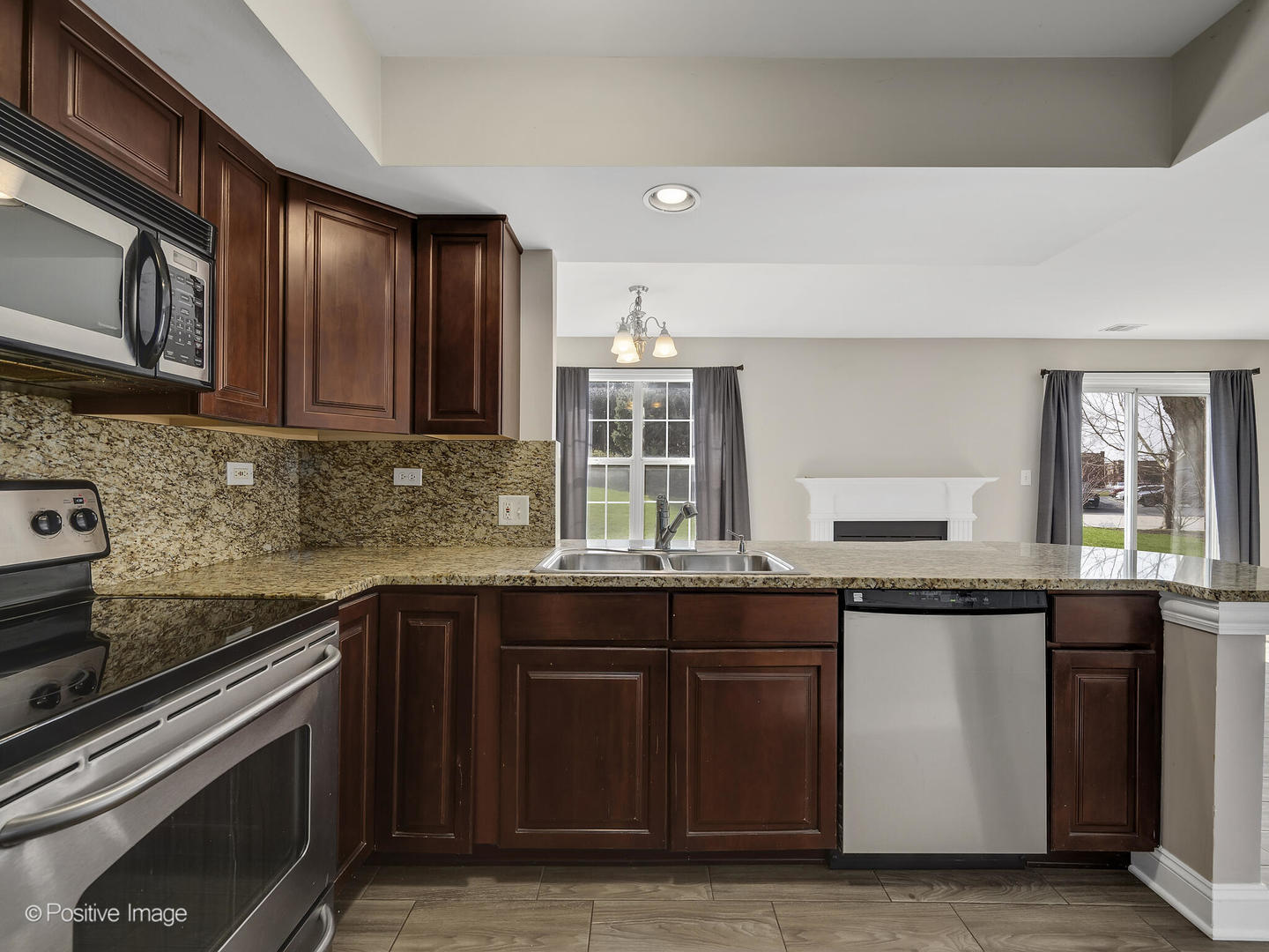 11 Foxcroft Road, Unit 115 Naperville, IL 60565 - Photo 8 of 17 a kitchen with stainless steel appliances granite countertop wooden cabinets stove top oven and sink