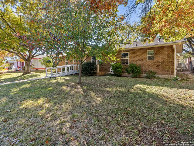 a view of a house with backyard and sitting area