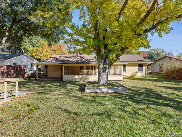 a front view of a house with a garden and trees