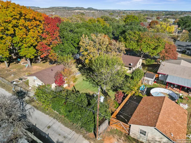 an aerial view of a house with a yard and a large tree