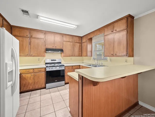 a kitchen with a sink stove top oven and cabinets