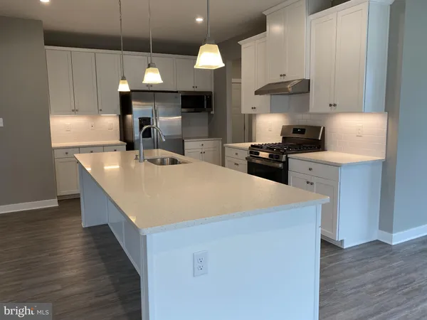a kitchen with stainless steel appliances granite countertop a sink a stove and a wooden floors