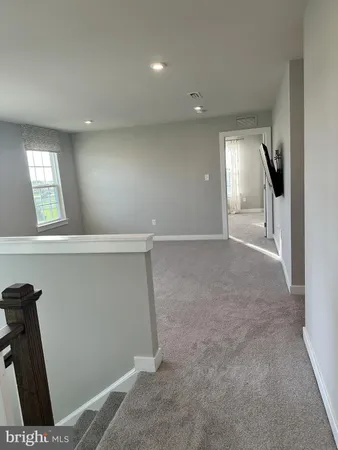 an empty room with wooden floor fireplace and windows