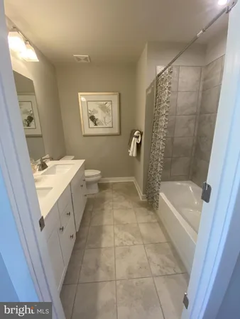 a bathroom with a granite countertop sink a toilet and bathtub