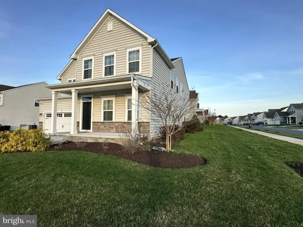 a front view of a house with a garden and plants