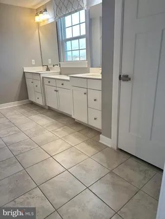a large bathroom with a double vanity sink mirror and window