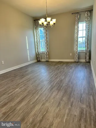 a view of a room with wooden floor and chandelier