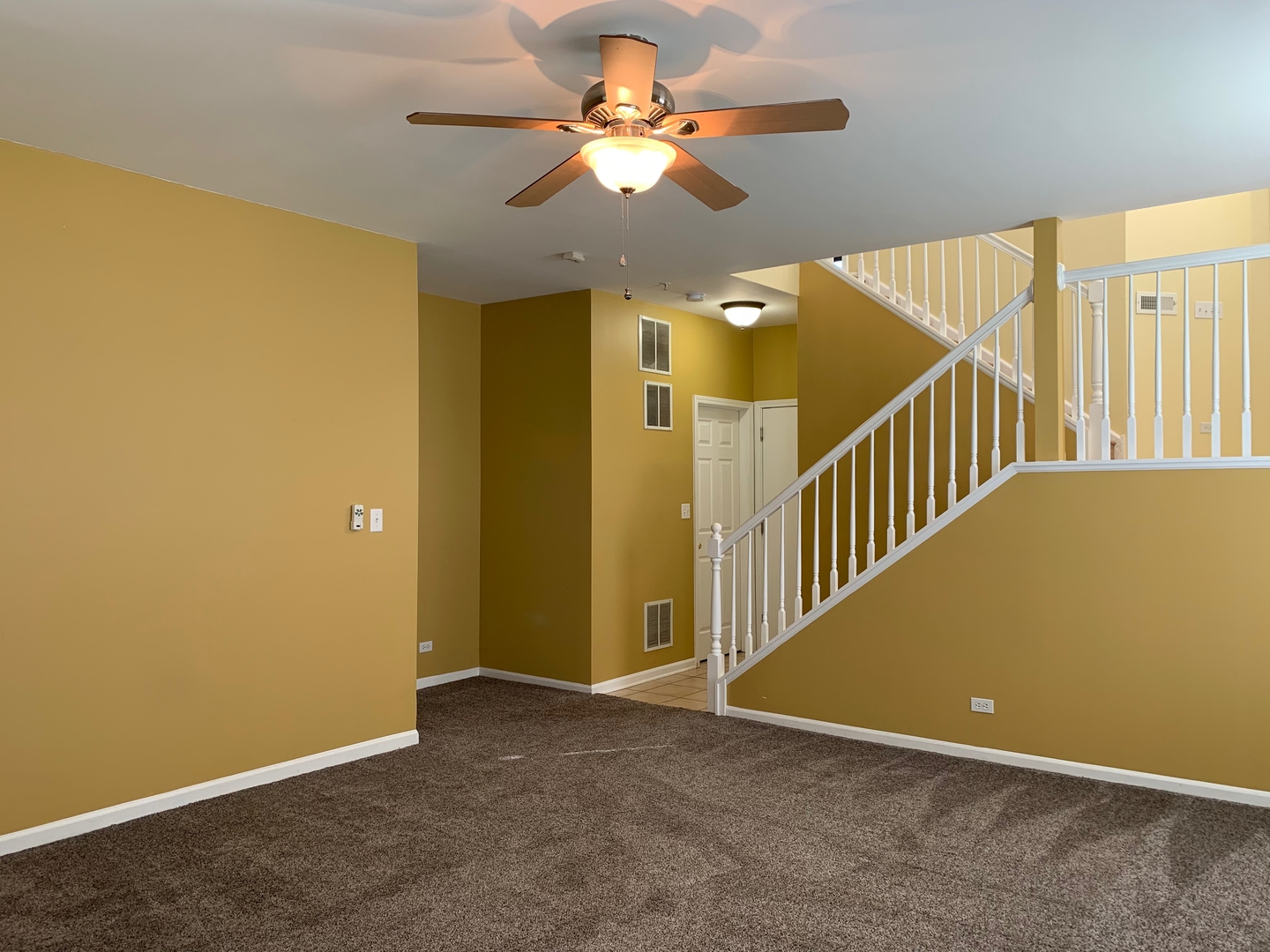 703 Riding Lane, Unit 703 St. Charles, IL 60174 - Photo 12 of 22 a view of a room with a ceiling fan and a chandelier