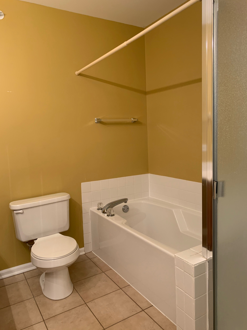703 Riding Lane, Unit 703 St. Charles, IL 60174 - Photo 17 of 22 a white toilet sitting next to a white tub